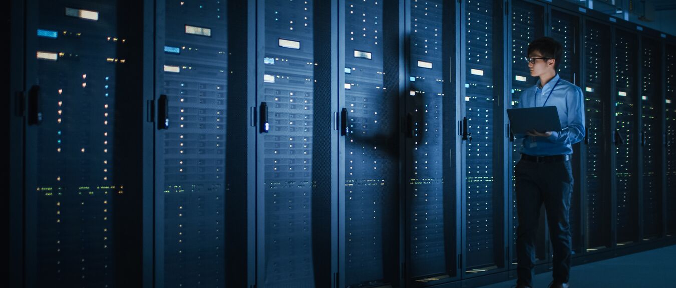 Data Center, Male IT Specialist Walks, Row of Operational Server Racks, Laptop, Maintenance. Cloud Computing, Artificial Intelligence, Supercomputer, Cybersecurity