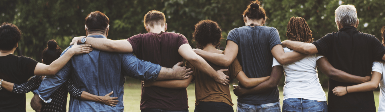 Group of diverse people standing with arms around each other